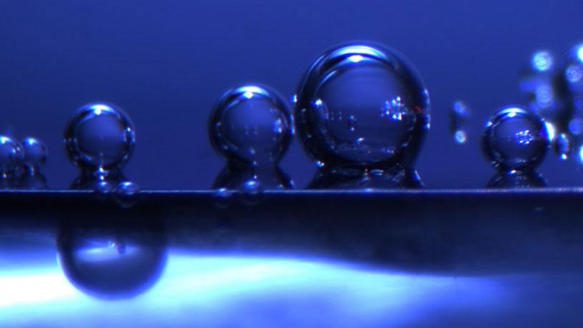 In-situ photo of hydrogen bubbles against a blue background.