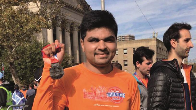 Pranay Dharmale holding a medal after a race.