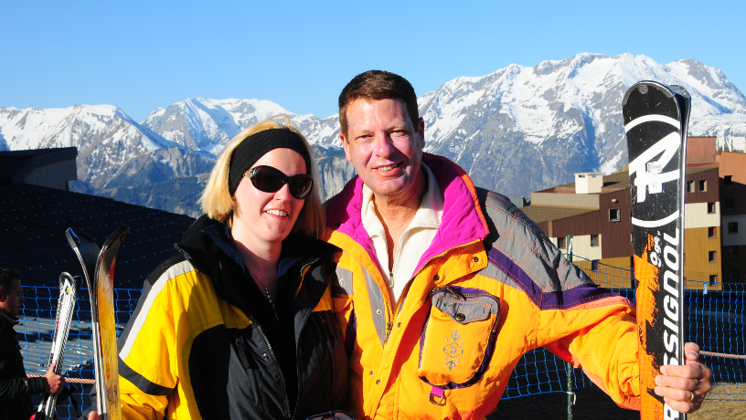 Yoseph Melman and wife during a ski trip with mountain in the background.