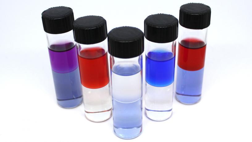5 sample tubes containing amine solvents extracting water from hypersaline brines.